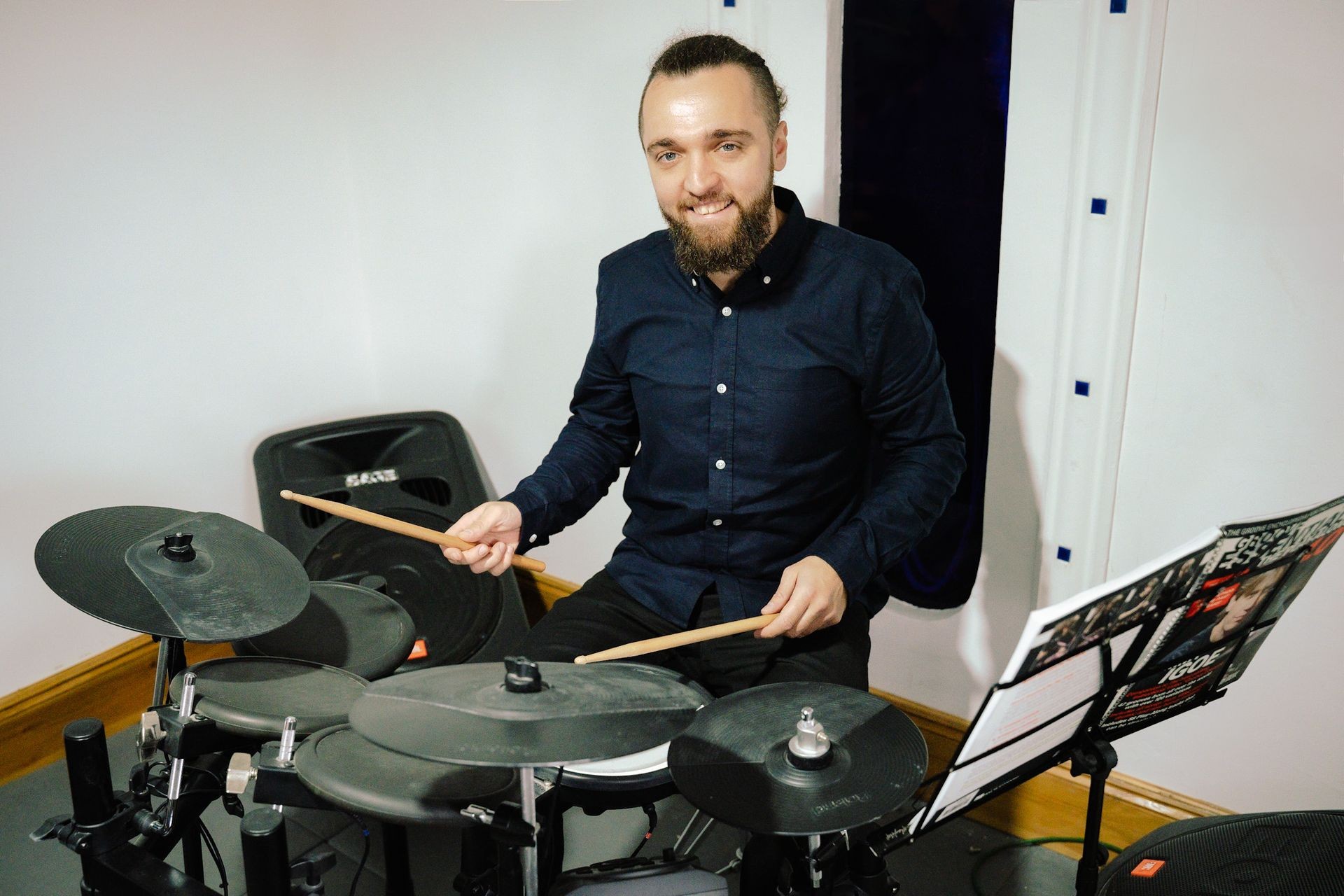 Person playing electronic drums in a music studio.